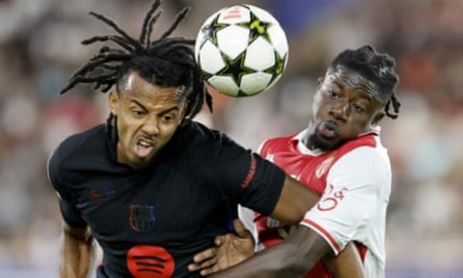 Jules Koundé grapples with Mohammed Salisu of Monaco in the Champions League