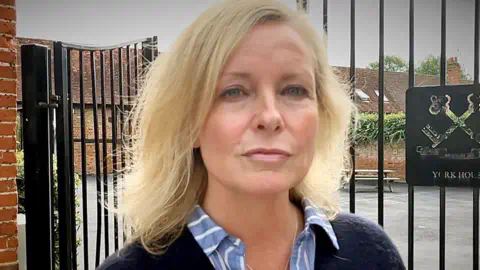 BBC Elaine Fraser outside the gates of the school where she works 